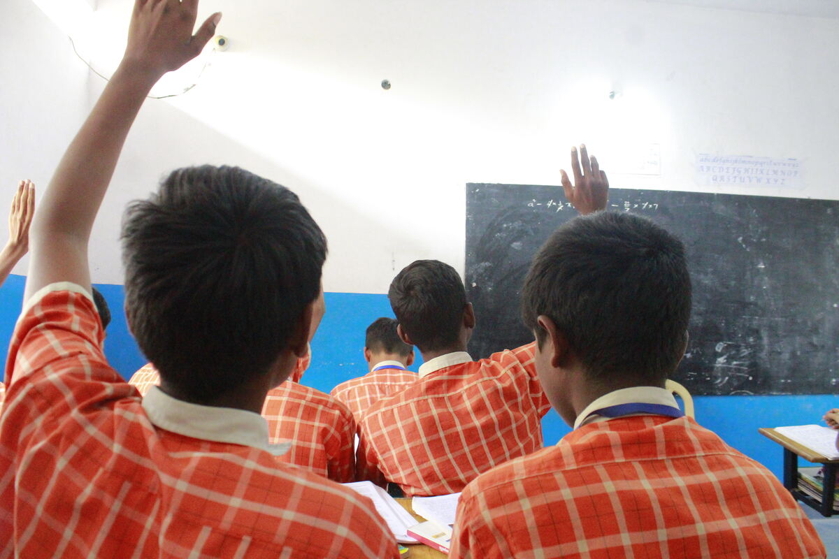 Students raising hands to answer in class