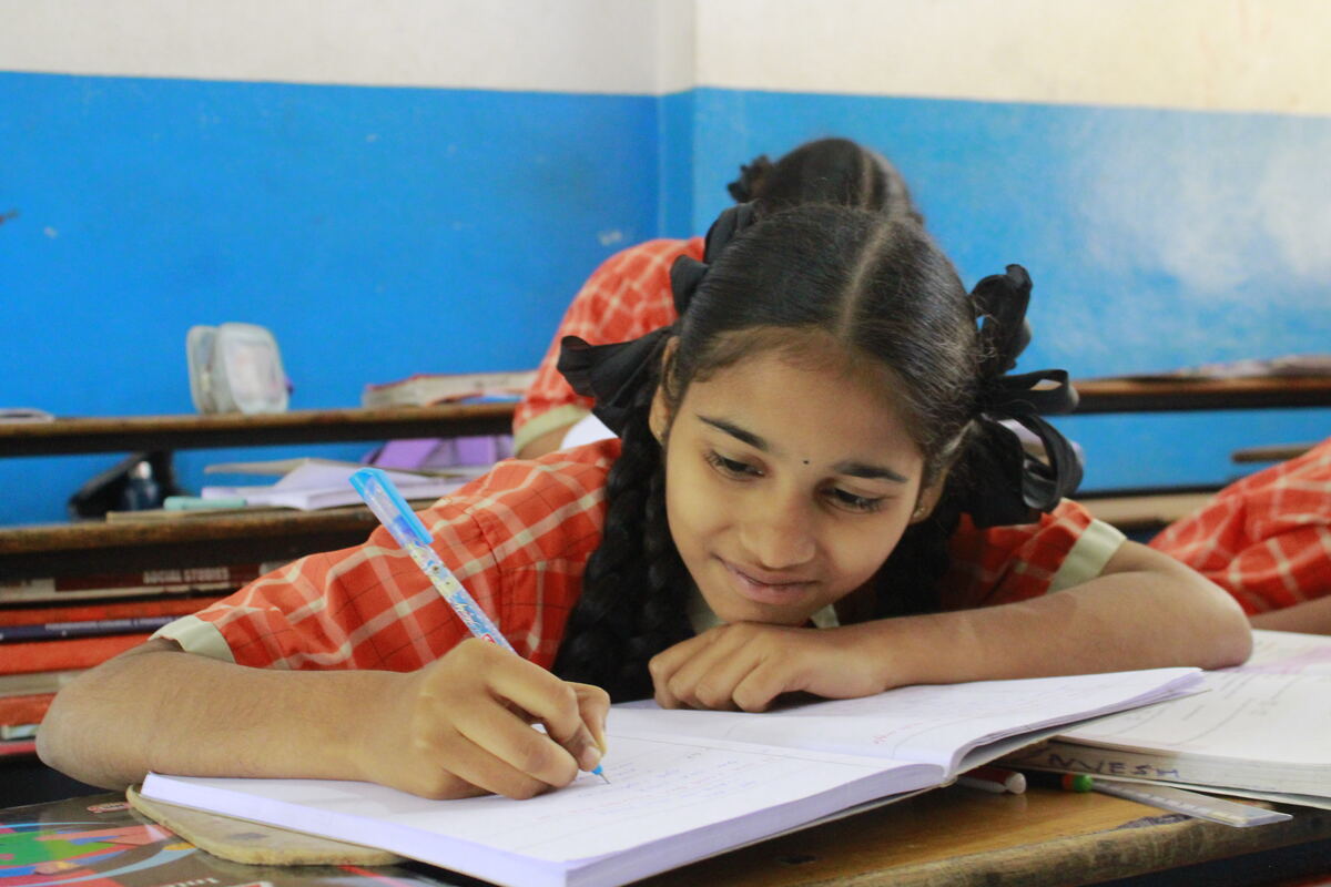 Student focused on writing in her notebook